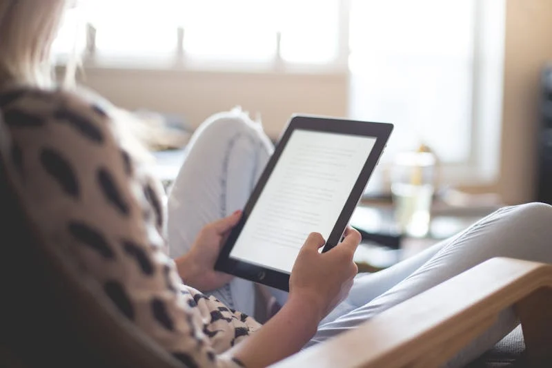 Fotografia de una joven tomando con sus manos un ipad