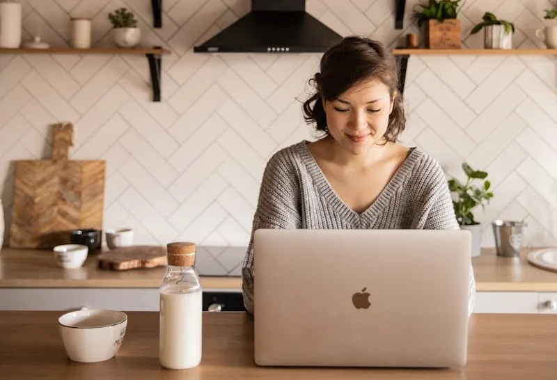 estudiante en su laptop que mira con alegria sus apuntes