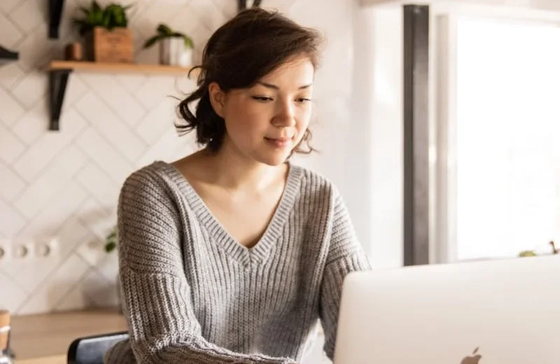 Fotografía de mujer frente a su laptop
