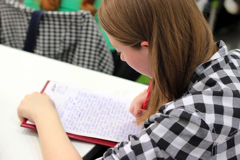 Fotografía de una joven mujer escribiendo en su libreta